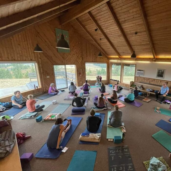 A group of people seated on yoga mats during a yoga retreat held in the Sunrise Chapel.
